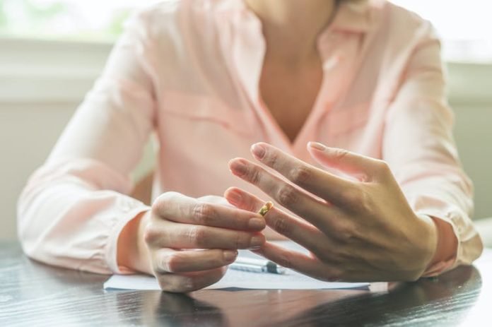 Woman holding her wedding ring | Image: Shutterstock