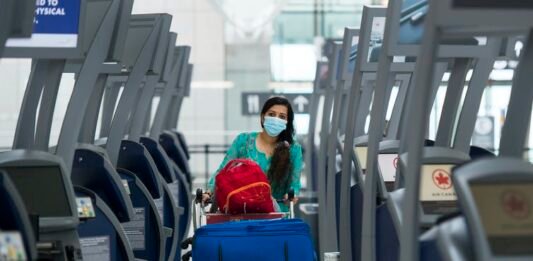 A traveller walks between empty check-in kiosks at Toronto’s Pearson International Airport in June 2020. THE CANADIAN PRESS/Nathan Denette