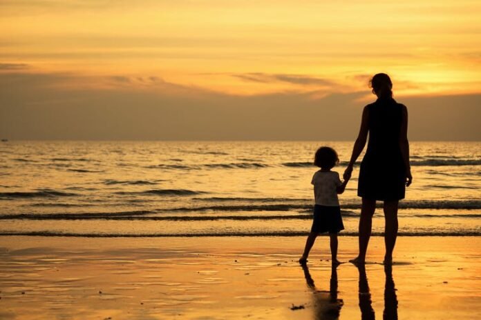 Mother and child at sunset on the beach | Photo: Shutterstock