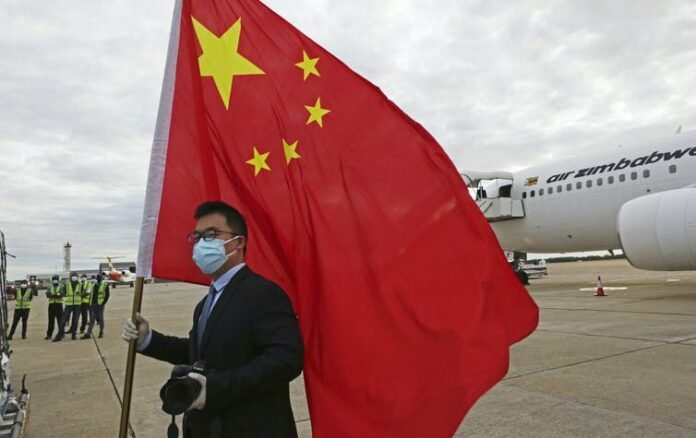 An official from the Chinese embassy in Zimbabwe greeting a plane carrying Sinopharm COVID-19 vaccines from China. Tsvangirayi Mukwazhi/AP